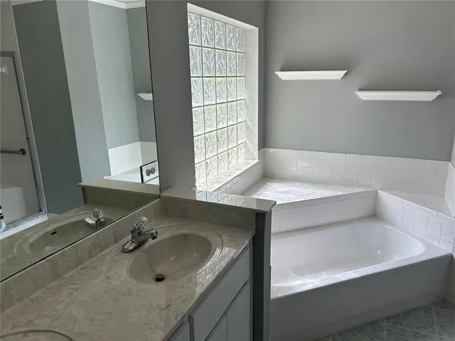 a bathroom with a tub sink and mirror