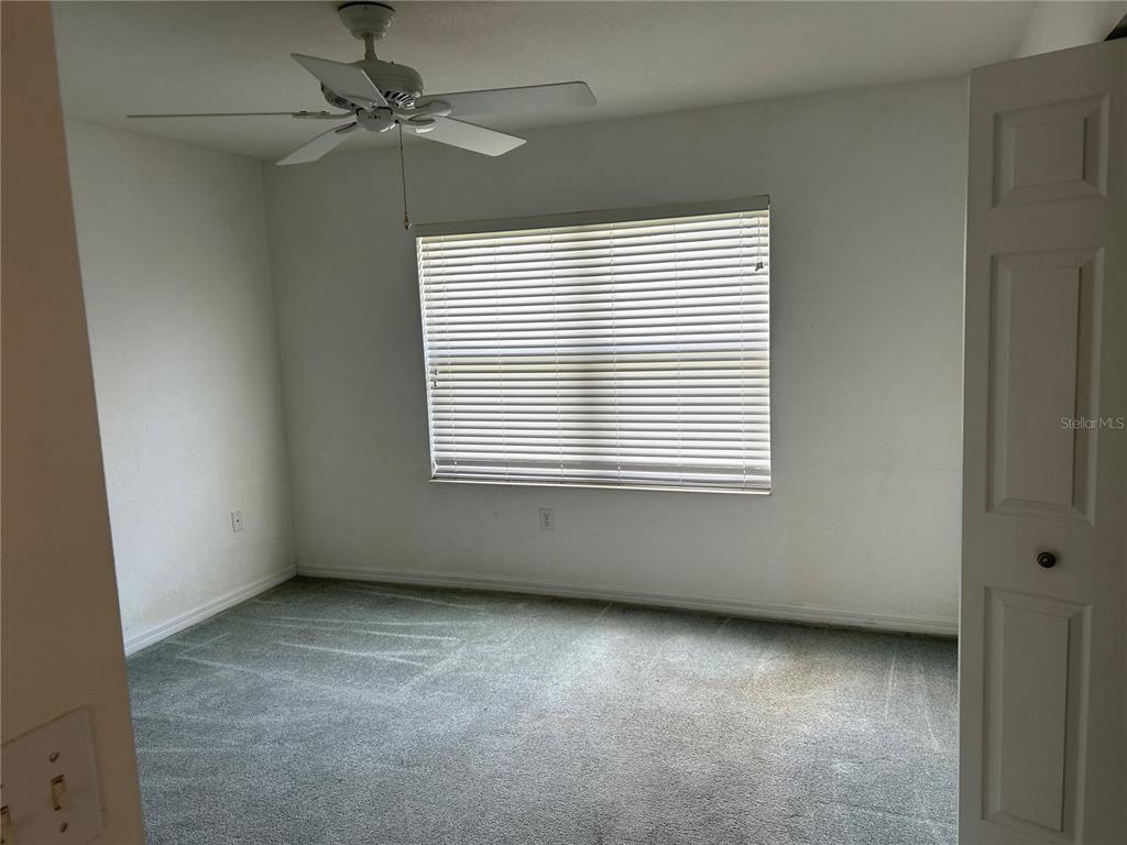 11014 Southwest 73rd Circle Ocala, FL 34476 - Photo 8 of 25 an empty room with a window and a fan