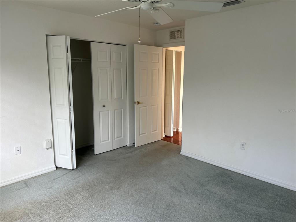 11014 Southwest 73rd Circle Ocala, FL 34476 - Photo 9 of 25 an empty room with a ceiling fan and closet area