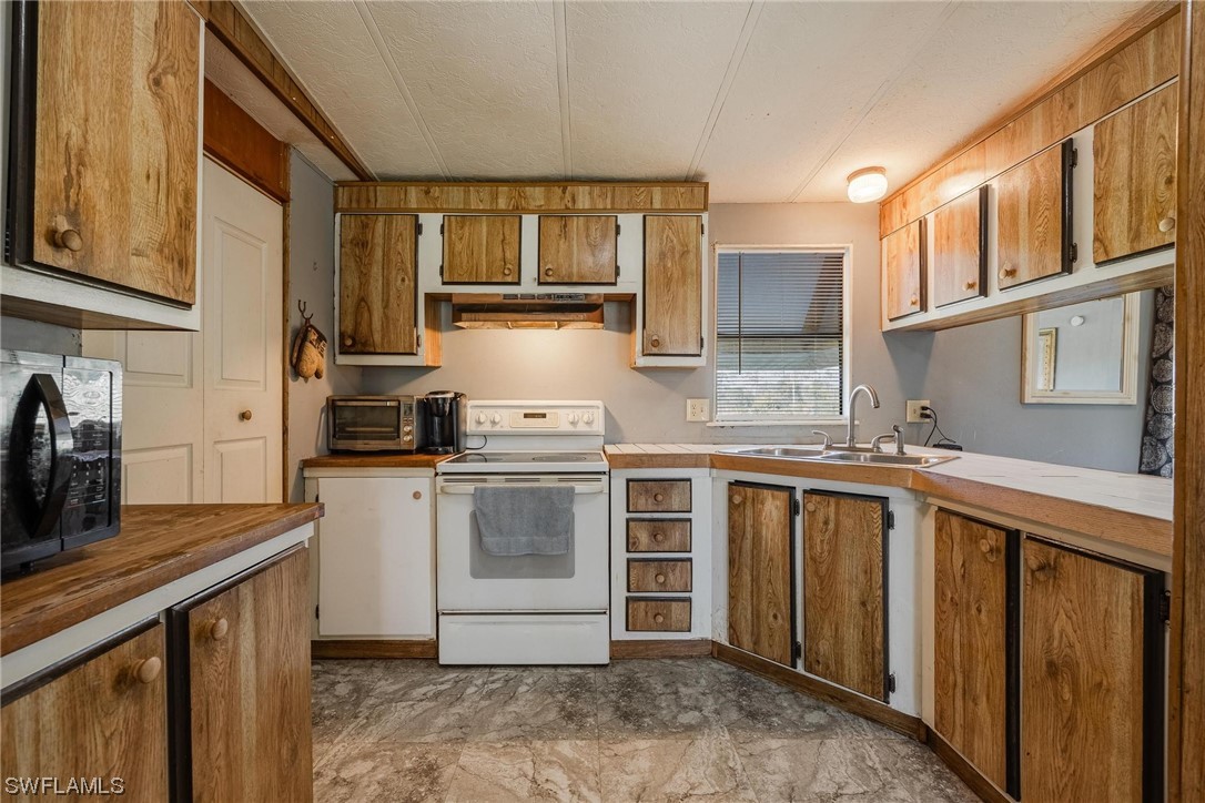 1315 Sunset Trail LaBelle, FL 33935 - Photo 5 of 23 a kitchen with stainless steel appliances granite countertop a sink stove and cabinets