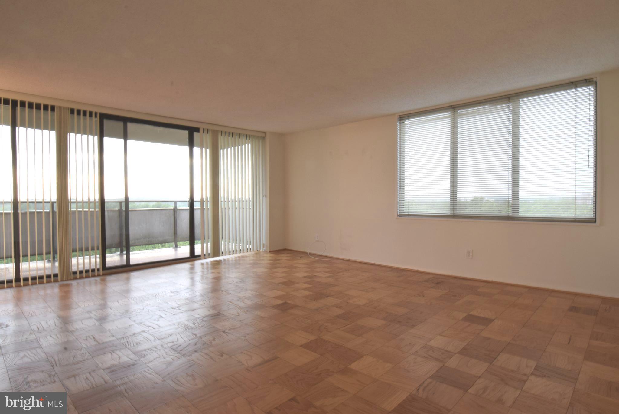 5225 Pooks Hill Road, Unit 1512N Bethesda, MD 20814 - Photo 7 of 26 an empty room with wooden floor and windows