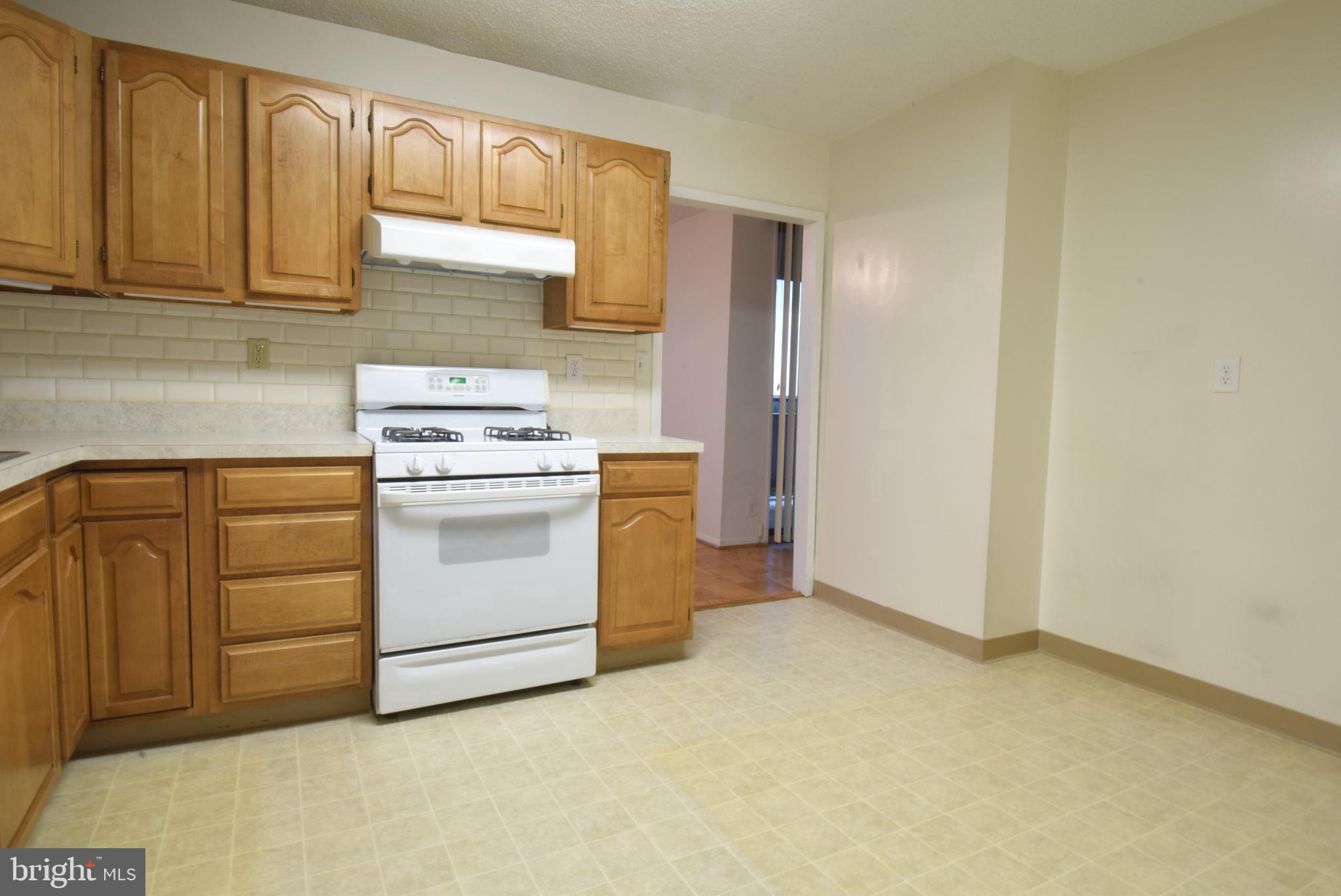 5225 Pooks Hill Road, Unit 1512N Bethesda, MD 20814 - Photo 10 of 26 a kitchen with white cabinets and white appliances