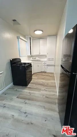 a view of kitchen with refrigerator stove and wooden floor