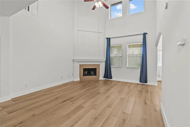 a view of empty room with wooden floor and fireplace