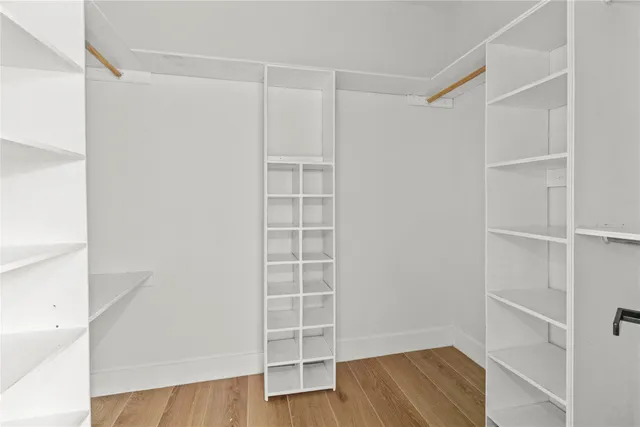 a view of walk in closet with empty racks