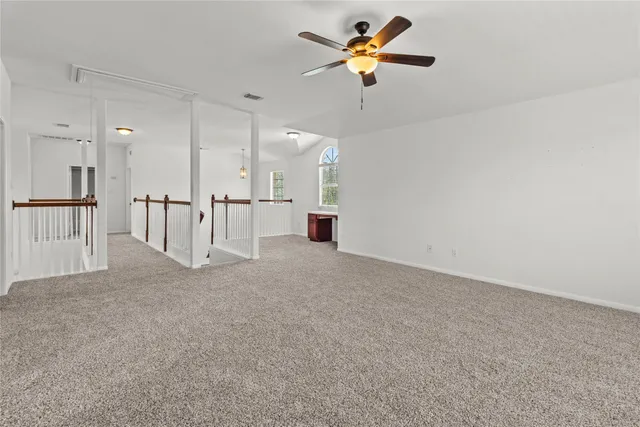 an empty room with a window and a fan