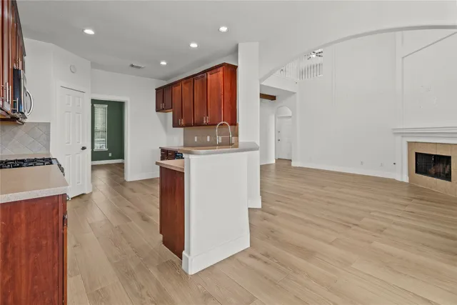 a open kitchen with stainless steel appliances granite countertop a stove top oven a sink and a refrigerator