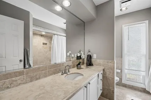 a bathroom with a granite countertop sink and a mirror
