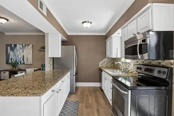 a kitchen with stainless steel appliances a stove and a microwave