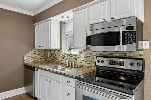 a kitchen with granite countertop kitchen island stainless steel appliances a table and chairs
