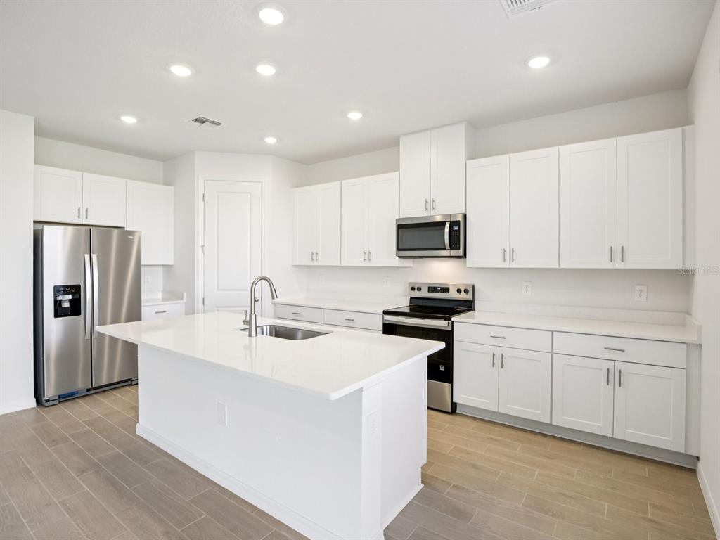 13311 Shellmore Avenue Palmetto, FL 34221 - Photo 11 of 46 a kitchen with a sink stainless steel appliances and white cabinets