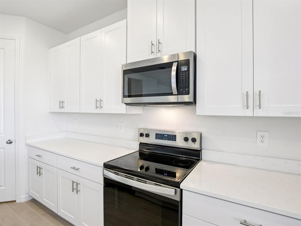 13311 Shellmore Avenue Palmetto, FL 34221 - Photo 12 of 46 a kitchen with granite countertop white cabinets and stainless steel appliances