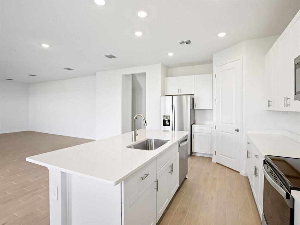 13311 Shellmore Avenue Palmetto, FL 34221 - Photo 13 of 46 a large white kitchen with a sink a refrigerator and a stove top oven