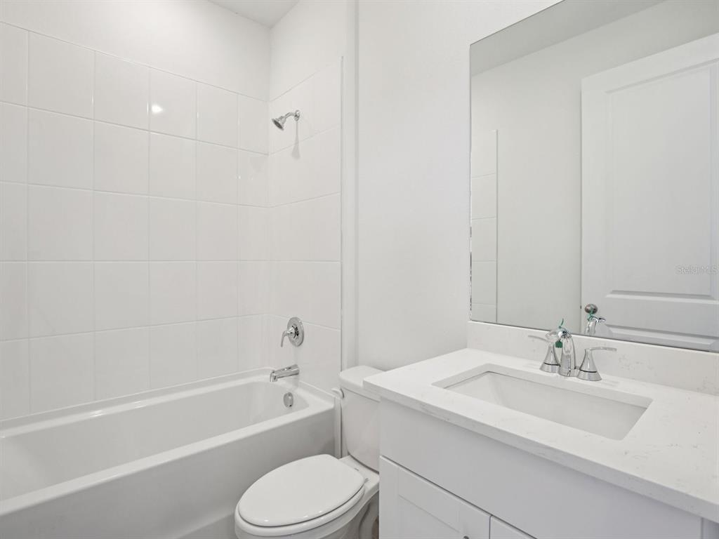 13311 Shellmore Avenue Palmetto, FL 34221 - Photo 18 of 46 a bathroom with a granite countertop sink toilet and bathtub