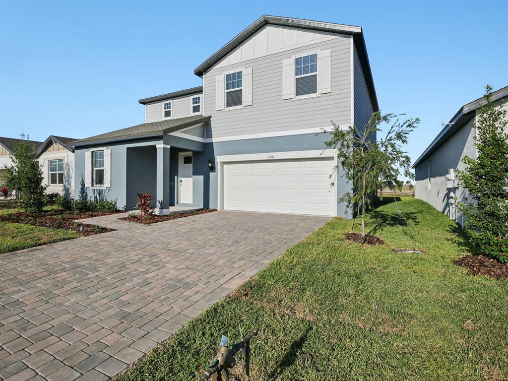 13311 Shellmore Avenue Palmetto, FL 34221 - Photo 2 of 46 a front view of a house with a yard and garage