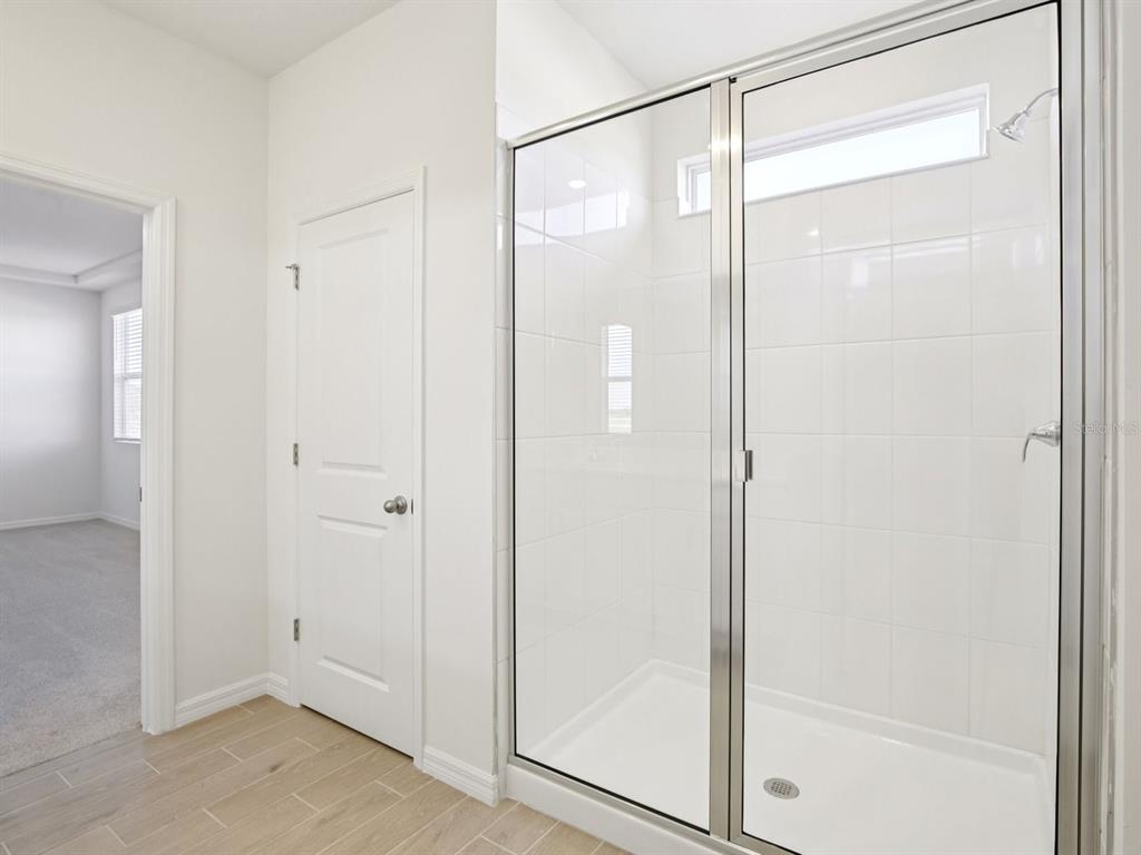 13311 Shellmore Avenue Palmetto, FL 34221 - Photo 30 of 46 a bathroom with a glass shower door