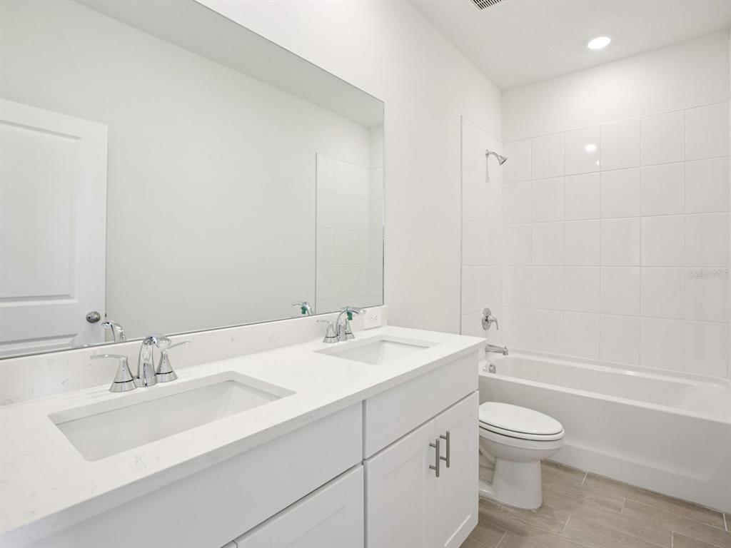13311 Shellmore Avenue Palmetto, FL 34221 - Photo 35 of 46 a bathroom with a granite countertop sink a toilet and a bathtub