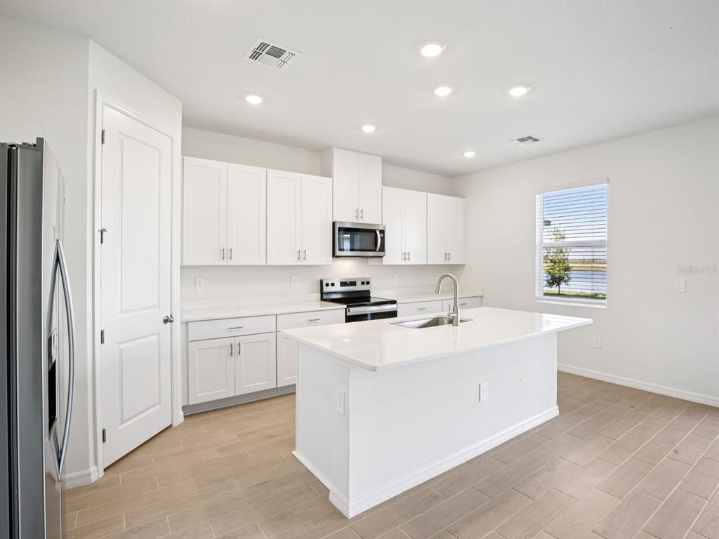 13311 Shellmore Avenue Palmetto, FL 34221 - Photo 10 of 46 a kitchen with stainless steel appliances granite countertop a sink stove and refrigerator
