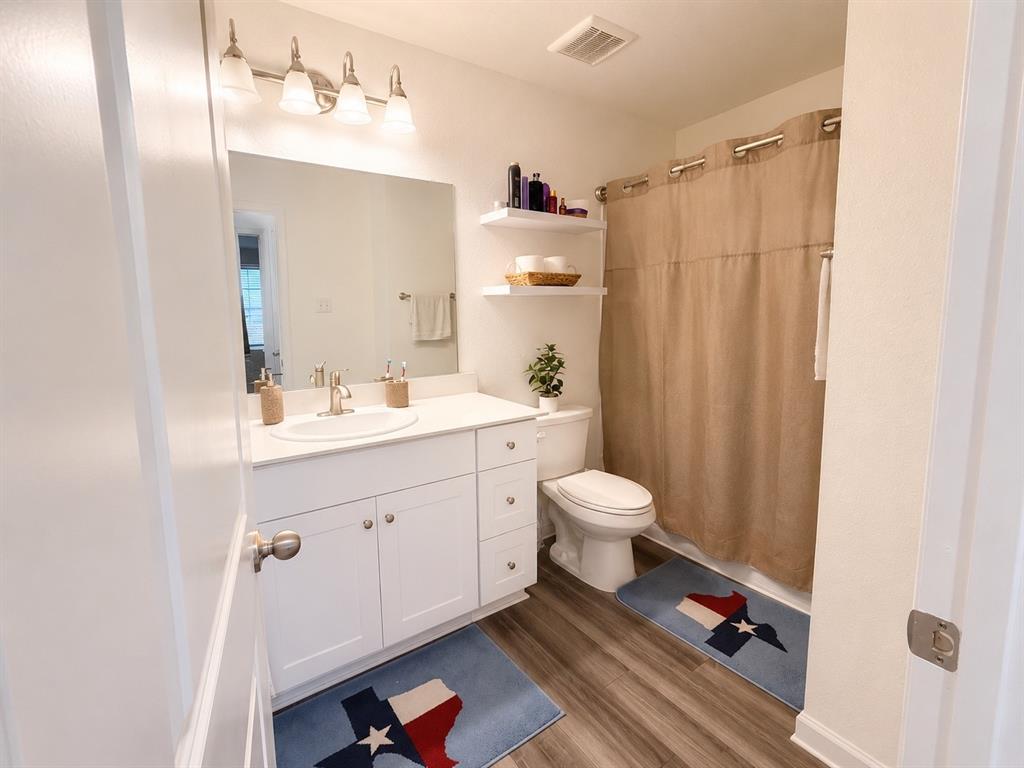 824 Juniper Street Anna, TX 75409 - Photo 13 of 25 Bathroom featuring a white vanity with an integrated sink, brushed nickel faucet, and a large wall-mounted mirror