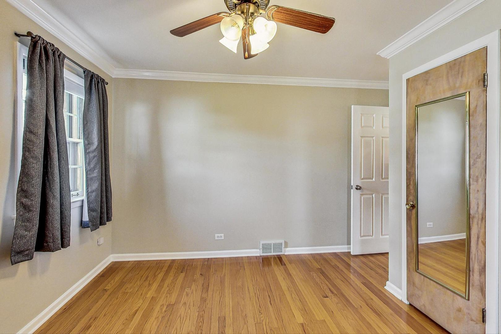 225 West Butterfield Road Elmhurst, IL 60126 - Photo 11 of 29 a view of an empty room with wooden floor and a window