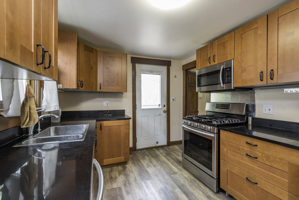 511 Chestnut Street Waukegan, IL 60085 - Photo 11 of 25 a kitchen with granite countertop wooden cabinets and a stove top oven