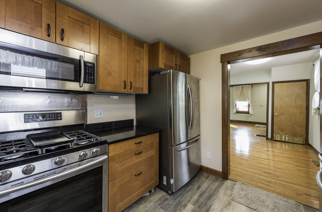 511 Chestnut Street Waukegan, IL 60085 - Photo 12 of 25 a kitchen with stainless steel appliances granite countertop a stove and a refrigerator