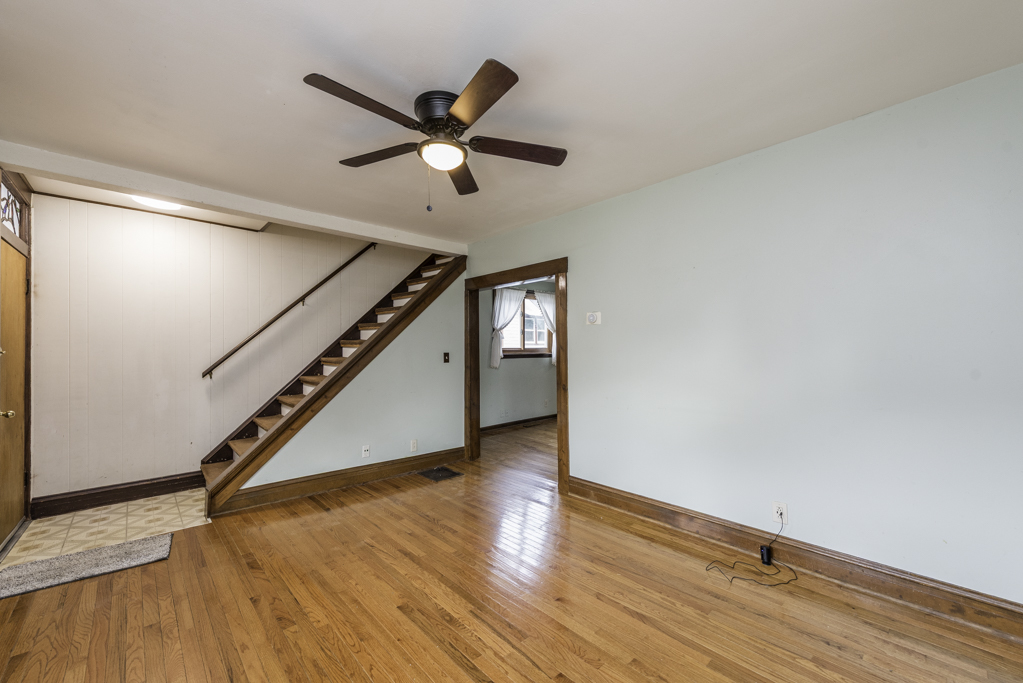 511 Chestnut Street Waukegan, IL 60085 - Photo 4 of 25 a view of an empty room with wooden floor and a ceiling fan