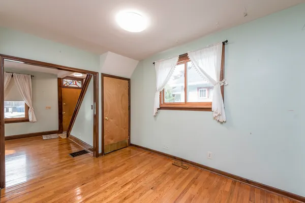 wooden floor in an empty room with a window