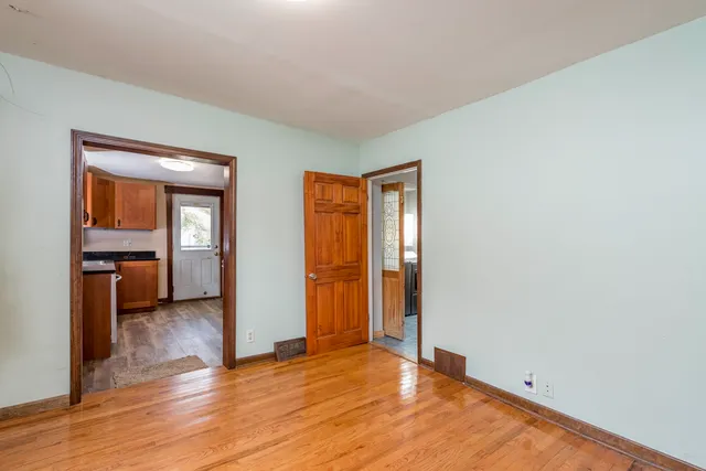 a view of empty room with wooden floor and windows