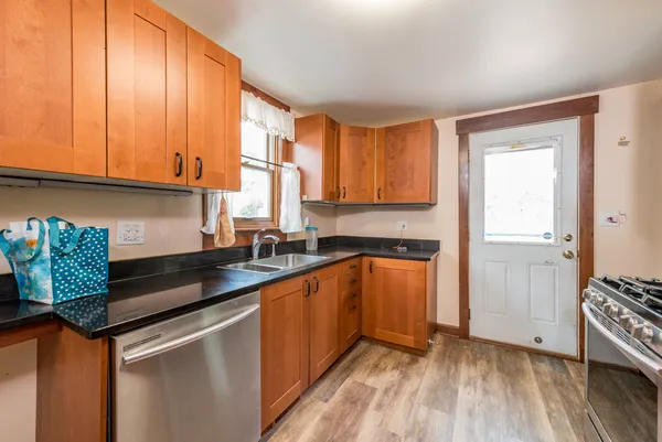 a kitchen with granite countertop a sink a stove and cabinets
