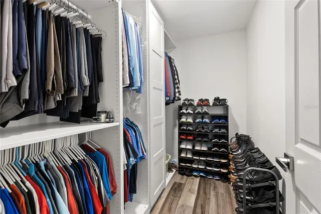 a view of walk in closet with clothes and shoes
