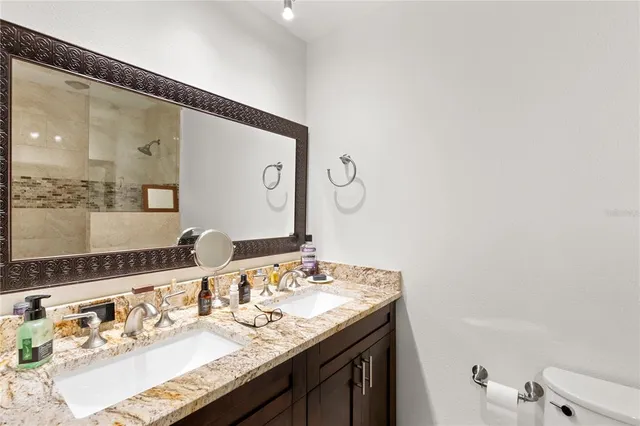 a bathroom with a granite countertop sink and a mirror