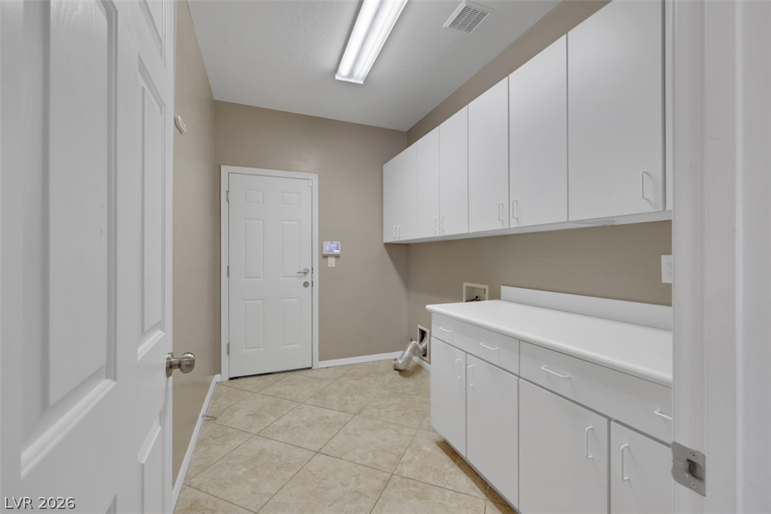 2501 Bechamel Place Henderson, NV 89044 - Photo 14 of 50 A well-appointed laundry room with ample white cabinetry and convenient utility hookups.