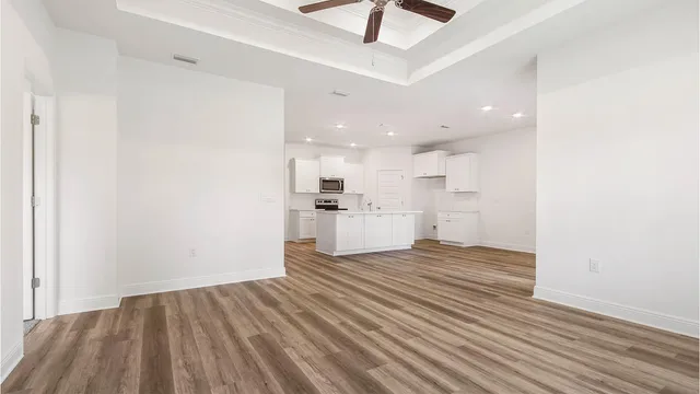 a view of a kitchen with wooden floor and a sink