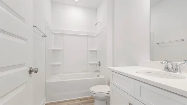 a bathroom with a granite countertop sink a toilet and a bathtub