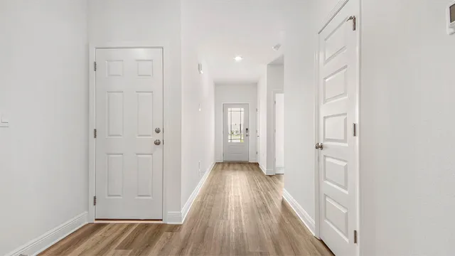 a view of a hallway with wooden floor and closet