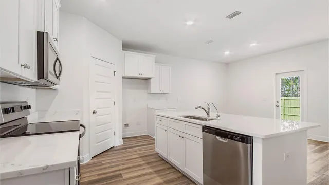 a kitchen with granite countertop a sink and a stove top oven
