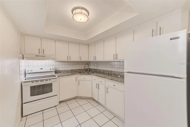 a kitchen with white cabinets and white appliances