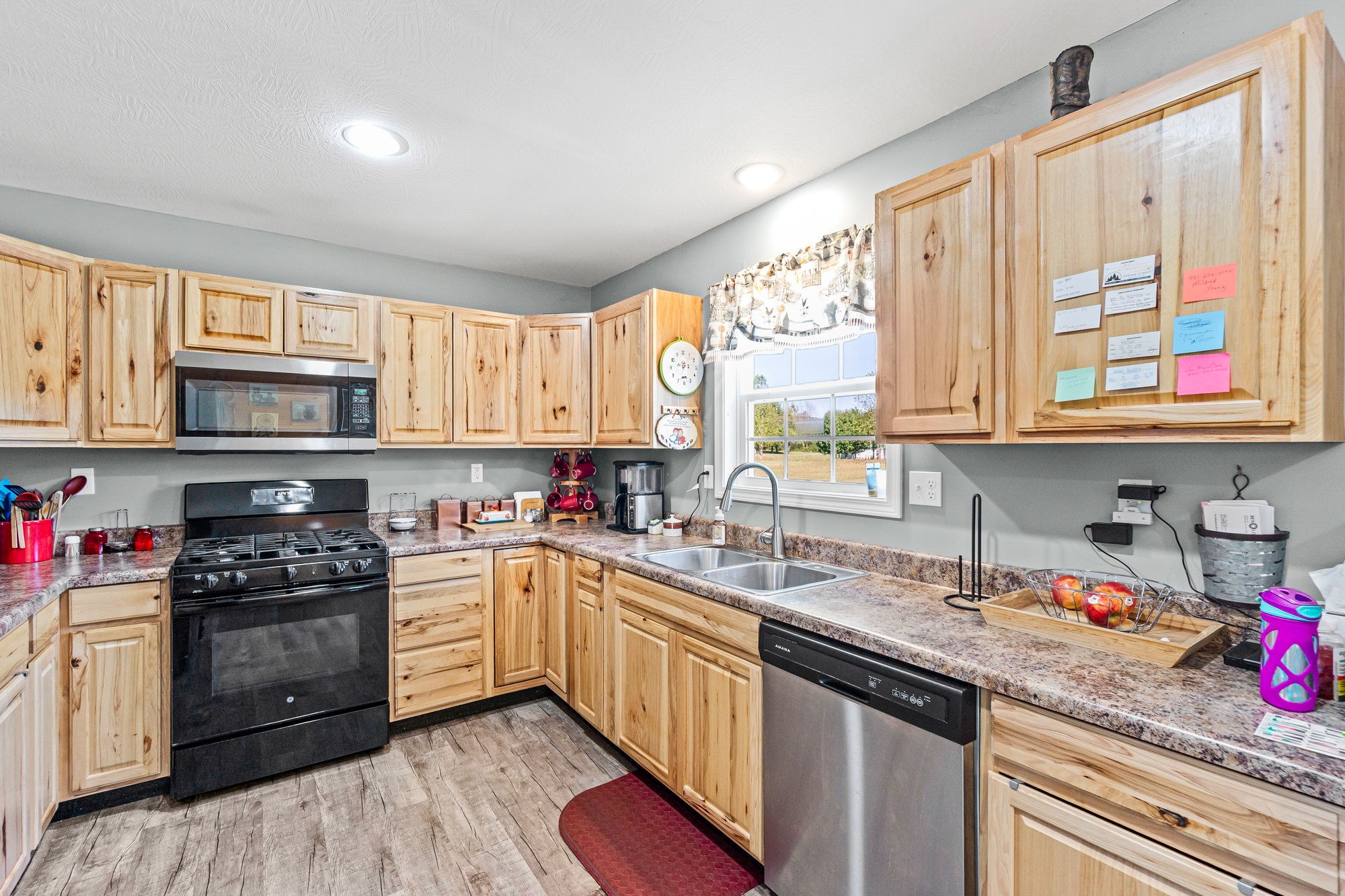 237 Fremont Road Doyle, TN 38559 - Photo 4 of 29 a kitchen with stainless steel appliances granite countertop a stove a sink dishwasher and white cabinets with wooden floor