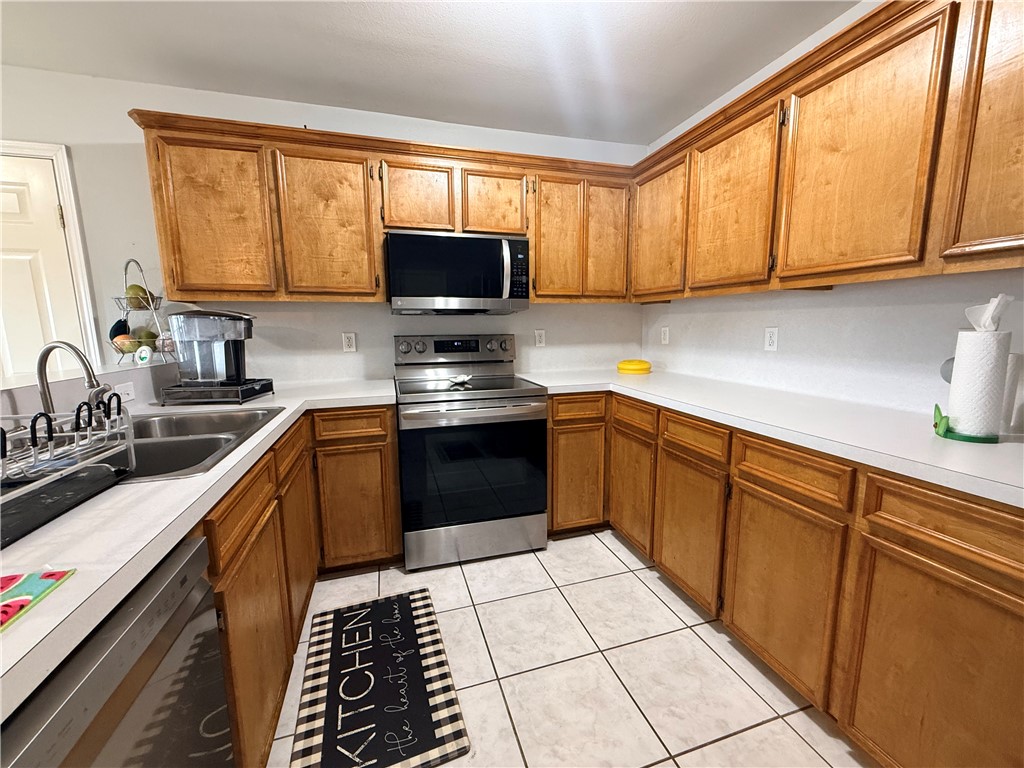 1938 El Monte Street Corpus Christi, TX 78417 - Photo 5 of 9 a kitchen with stainless steel appliances a sink dishwasher stove refrigerator and cabinets