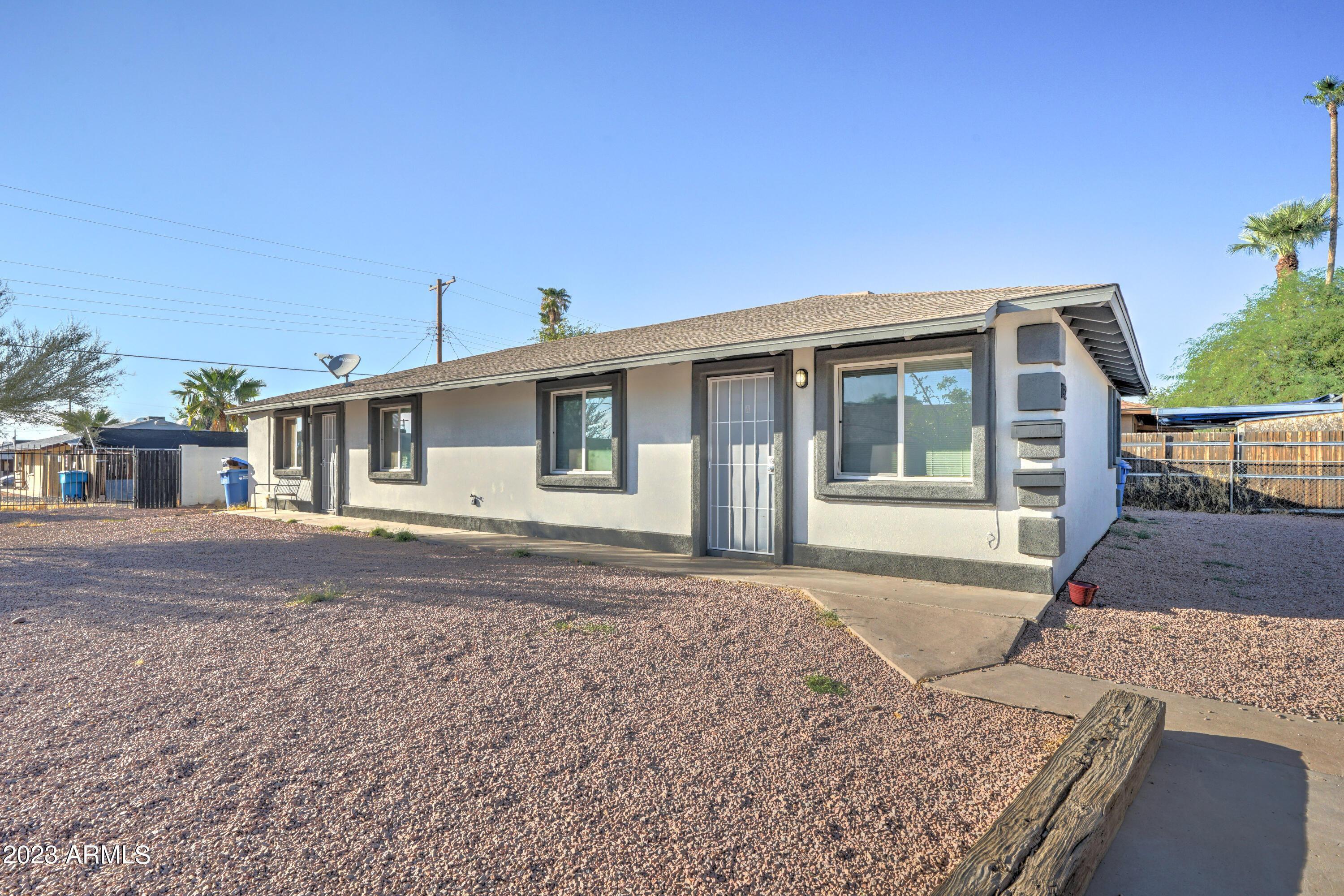 1202 North 49th Place, Unit A Phoenix, AZ 85008 - Photo 1 of 14 a front view of a house with a garden