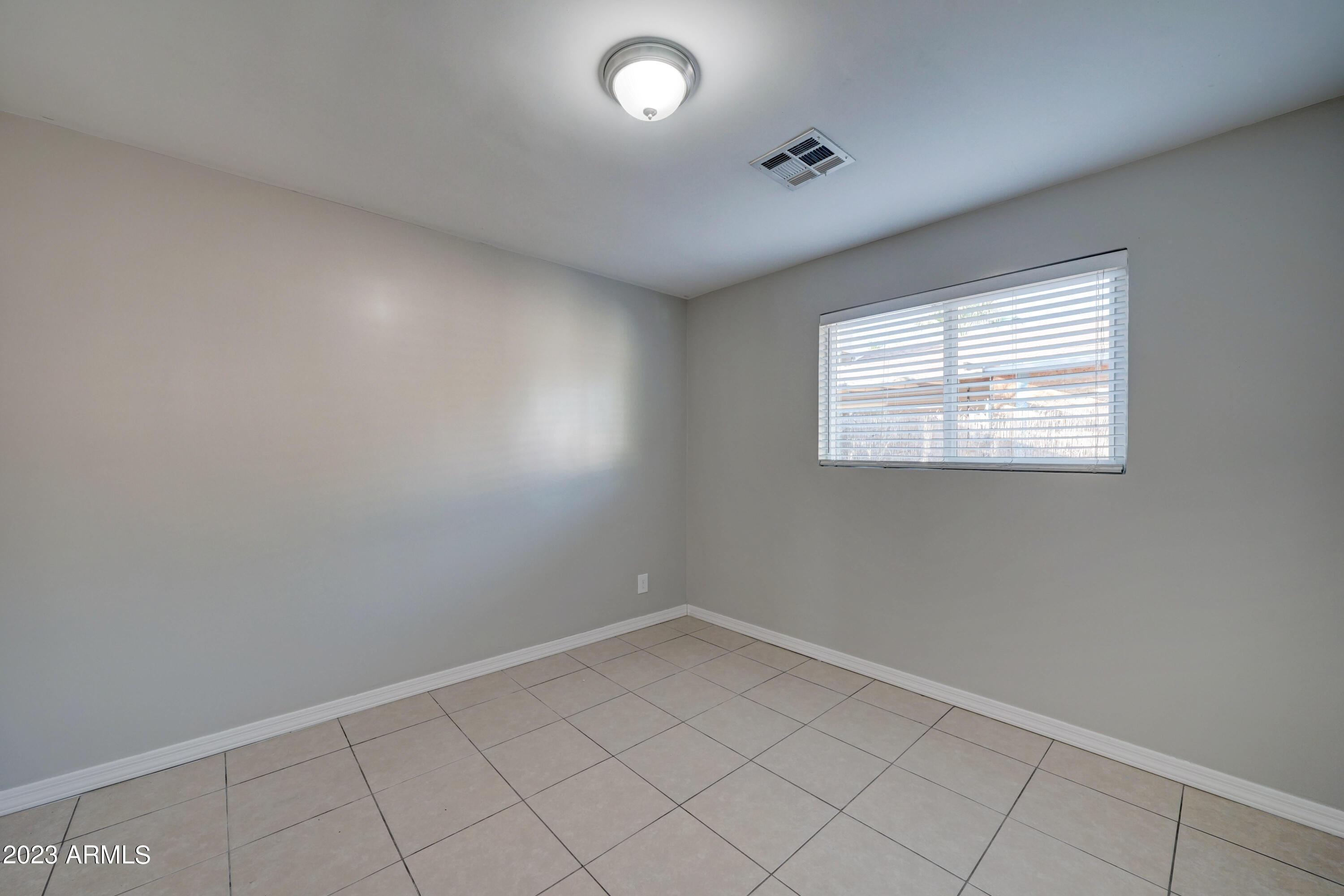 1202 North 49th Place, Unit A Phoenix, AZ 85008 - Photo 12 of 14 an empty room with windows