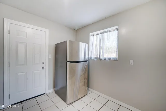 a view of a refrigerator in kitchen and white cabinets