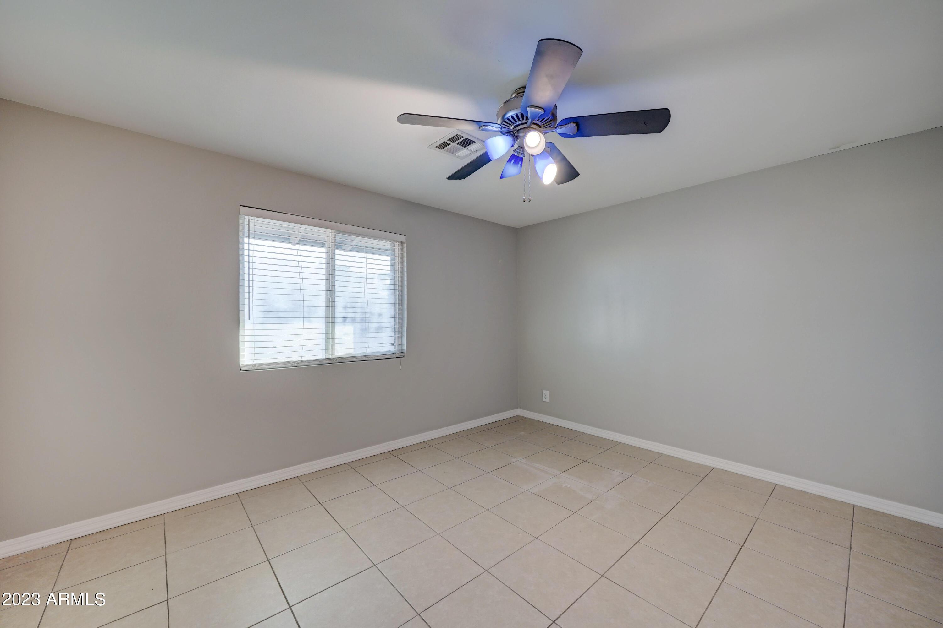 1202 North 49th Place, Unit A Phoenix, AZ 85008 - Photo 9 of 14 an empty room with windows and fan