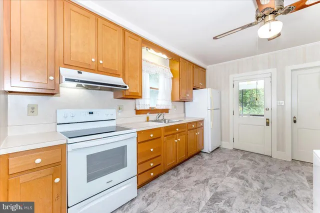 a kitchen with granite countertop white cabinets and white appliances