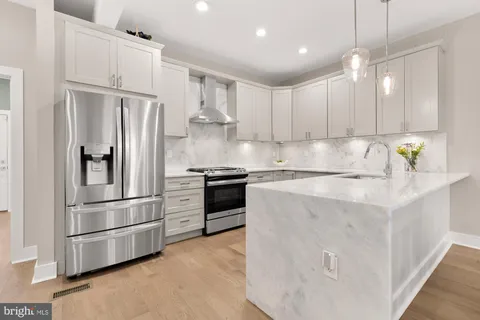 a kitchen with stainless steel appliances a refrigerator sink and cabinets