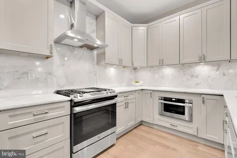 a kitchen with granite countertop stainless steel appliances a stove a microwave and cabinets