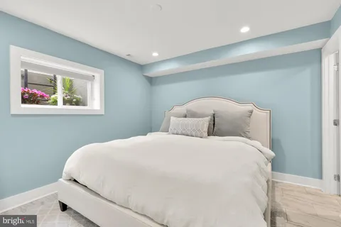 a large bed sitting in a bedroom next to a window