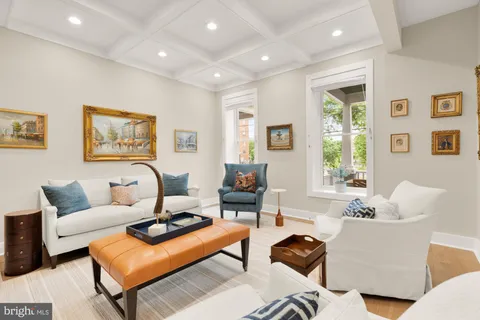 a living room with furniture a large window and a dining table