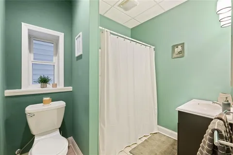a bathroom with a toilet sink and mirror